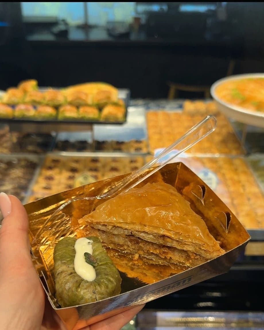 A box of baklava held up outside the shop in Mostar