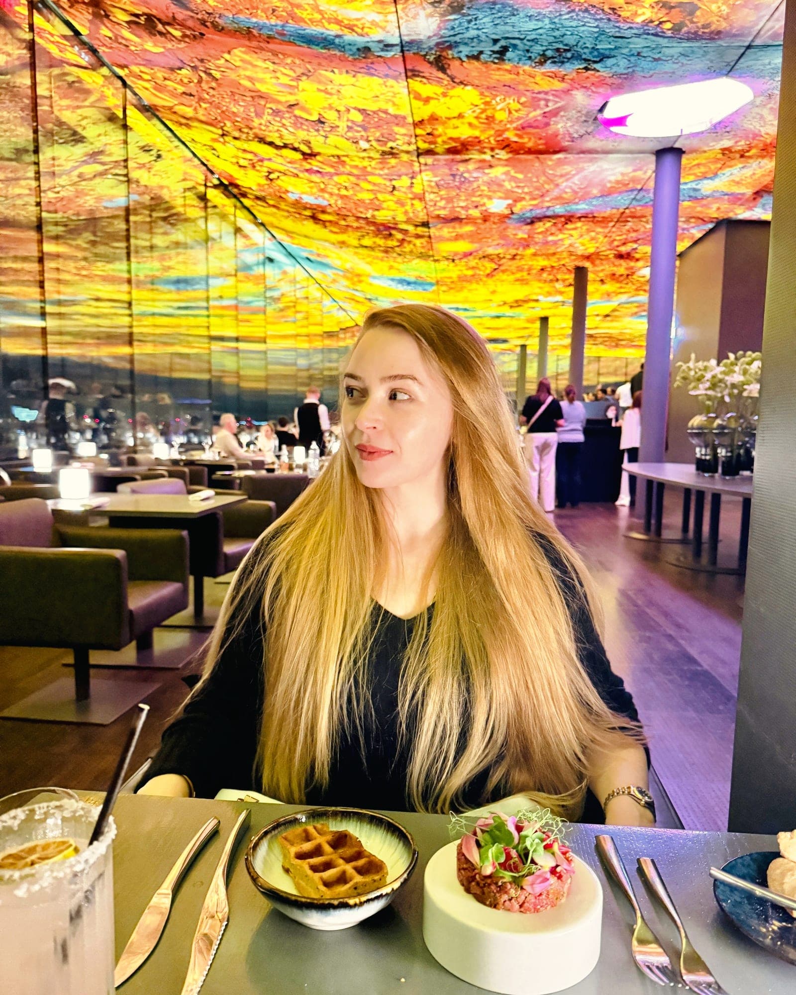 Eva at the table under the coloured ceiling at Das Loft