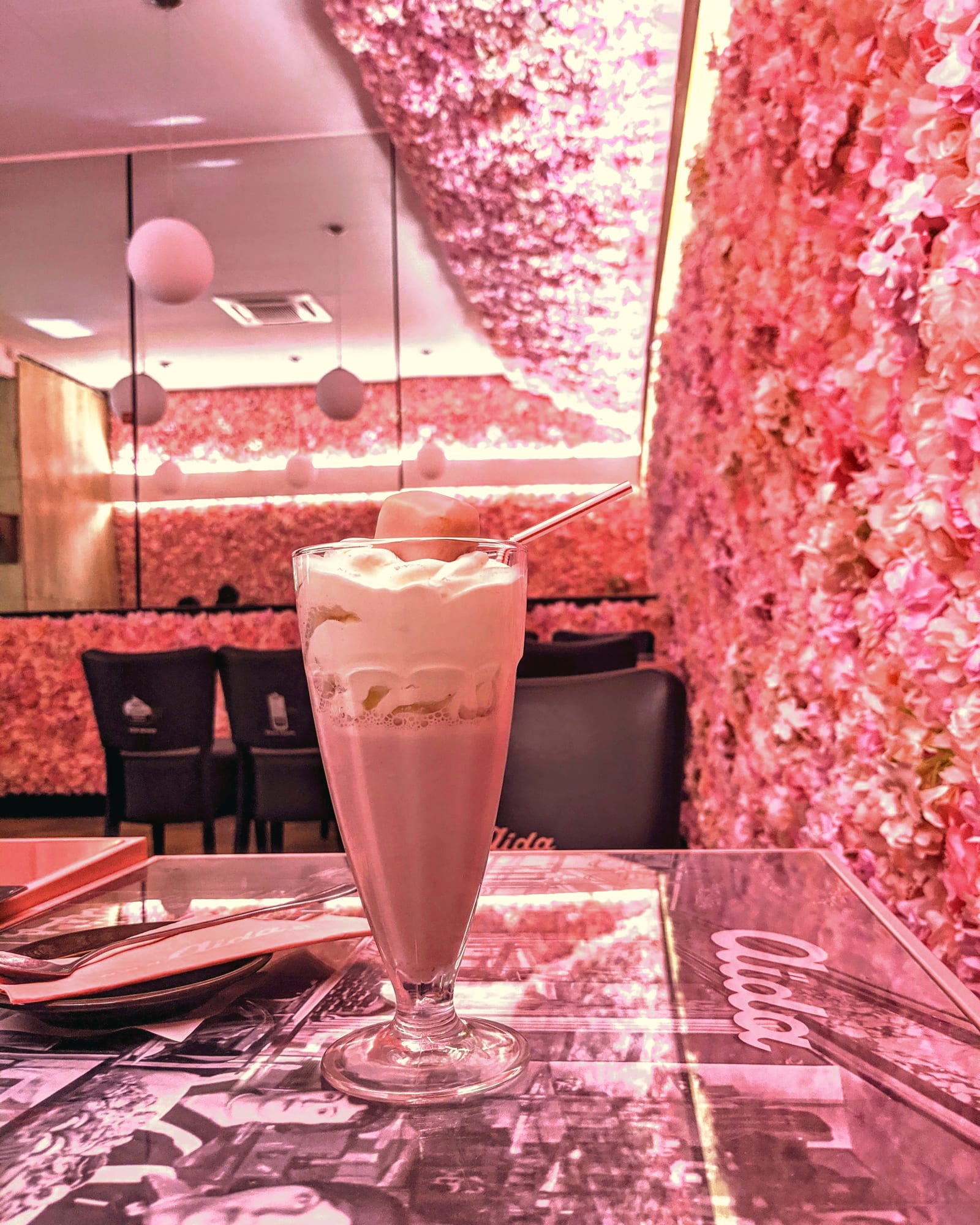 A milkshake at Aida, against the café's pink flower wall
